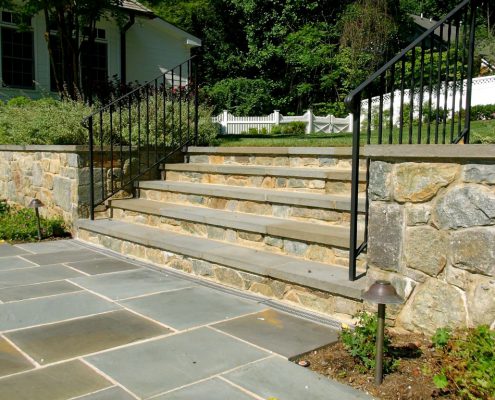 Stone steps coordinate with the stone retaining wall